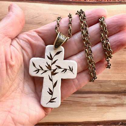 engraved cream colored wooden cross 